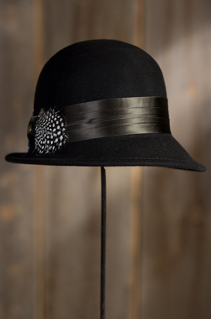 Rising to fashion in the 1920s under the French word for bell, the cloche is the feminine hat of choice for sophistication and simplicity that can be tilted to the side. The Vilma Cloche embraces the mood and spirit of 1950s jazz, with a 4 ½”crown, an asymmetrical 1½”– 2 ½” brim, and a wide 2” band detailed with a spotted pheasant feather bow on pleated silk. Crafted from premium wool felt from New Zealand, the Vilma crowns you with vintage beauty. 100% wool with satin lining. Imported. Classic Adjustable Mini Hat With Short Brim, Classic Adjustable Mini Hats For Formal Occasions, Fitted Cloche Hat With Short Brim, Adjustable Cloche Hat For Fall Party, Evening Gatsby Hat With Short Brim, Classic Brimmed Mini Hat For Kentucky Derby, Gatsby Style Cloche Hat For Kentucky Derby, Adjustable Brimmed Cloche Hat For Kentucky Derby, Classic Mini Hats With Short Brim For Party