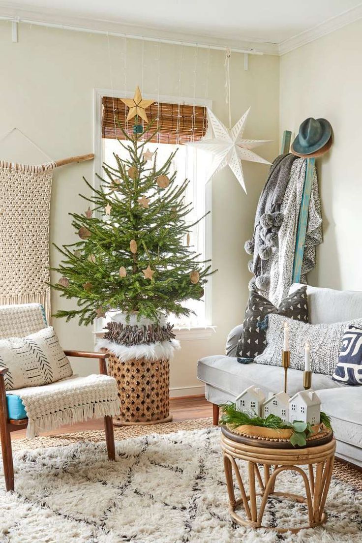 a living room with a christmas tree in the corner and other decorations on the table