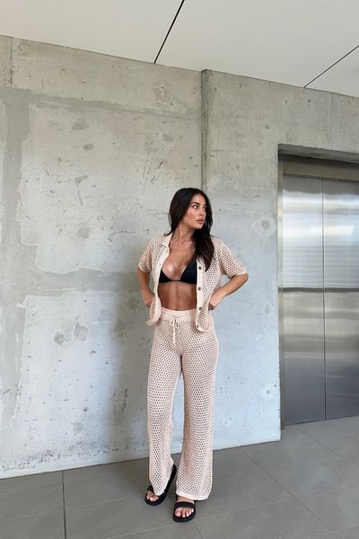 Good news -- we're restocking this style soon! If your size is sold out, select your size and register your email to be notified when it's available. Our Jaida Pant features a full length, cheeky style short lining, elastic band on the waist with drawstring, hollow crochet knit fabric and relaxed fit. Matching with Jaida Top and Suki Top. This garment has cheeky style short lining and stretchy. 85% Viscose, 15% Nylon. Please fold knitted garments. Do not hang to avoid stretching. Please refer to