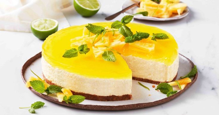 a cheesecake on a plate with limes and mint