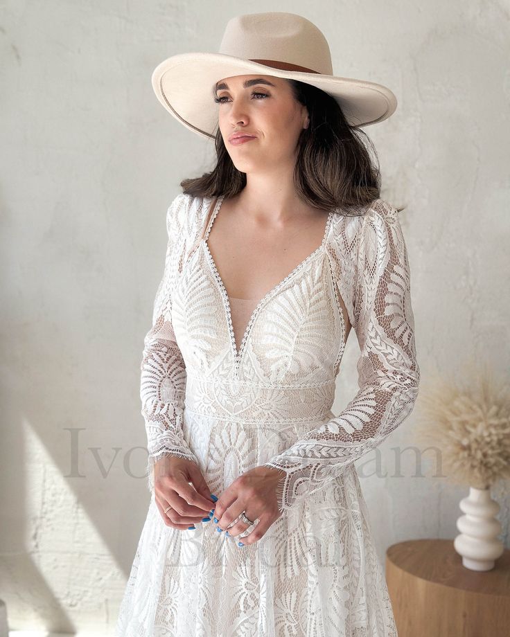 a woman in a white dress and hat poses for the camera with her hands on her hips