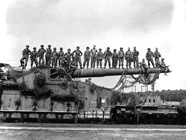 black and white photograph of men standing on top of an old tank