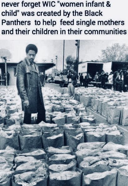 an old black and white photo with people in front of boxes full of food items