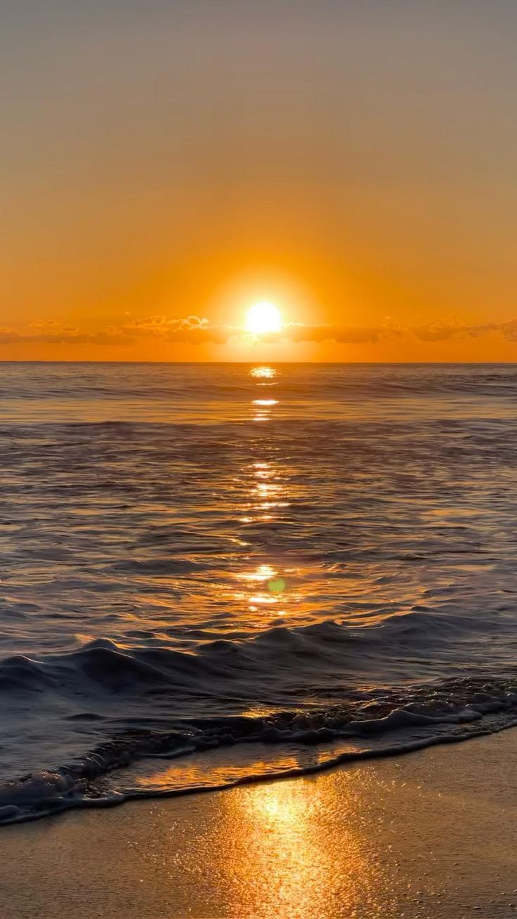 the sun is setting over the water at the beach