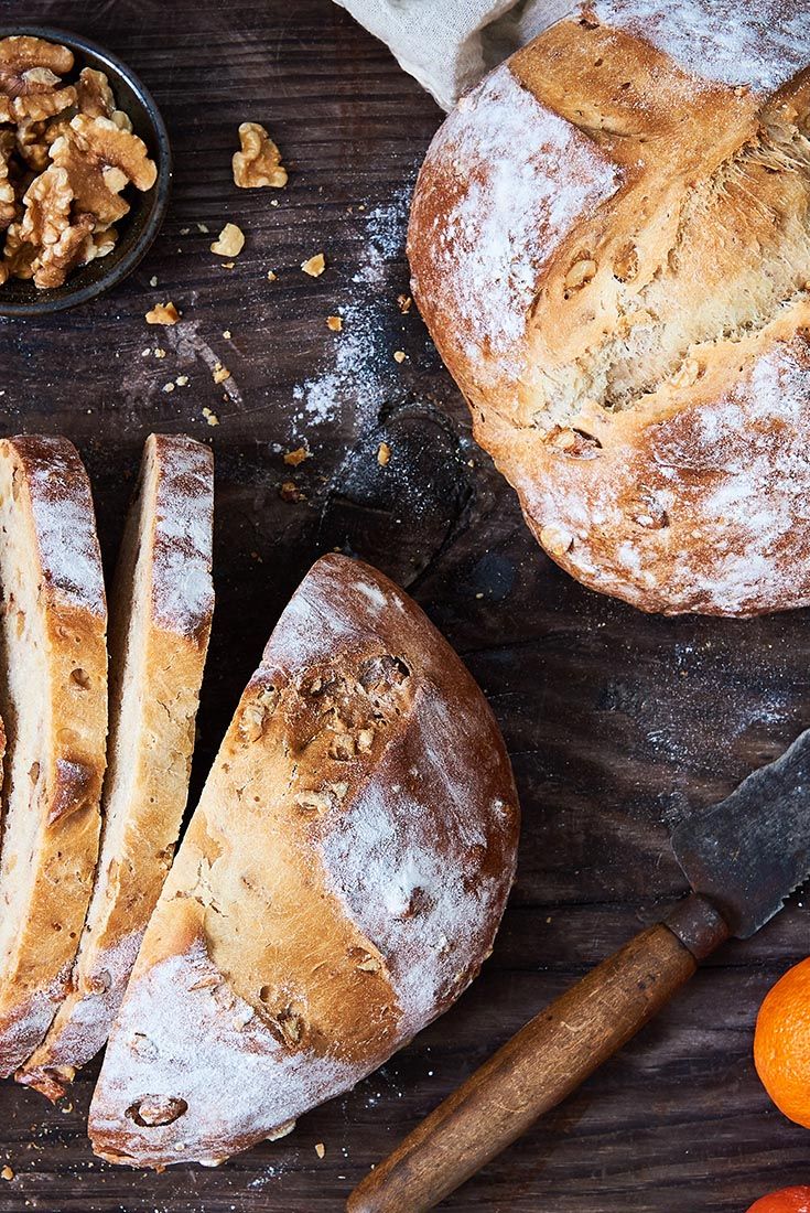 bread, nuts and oranges on a wooden table