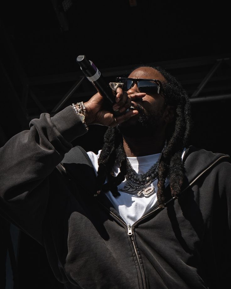 a man with dreadlocks on his head holding a cell phone