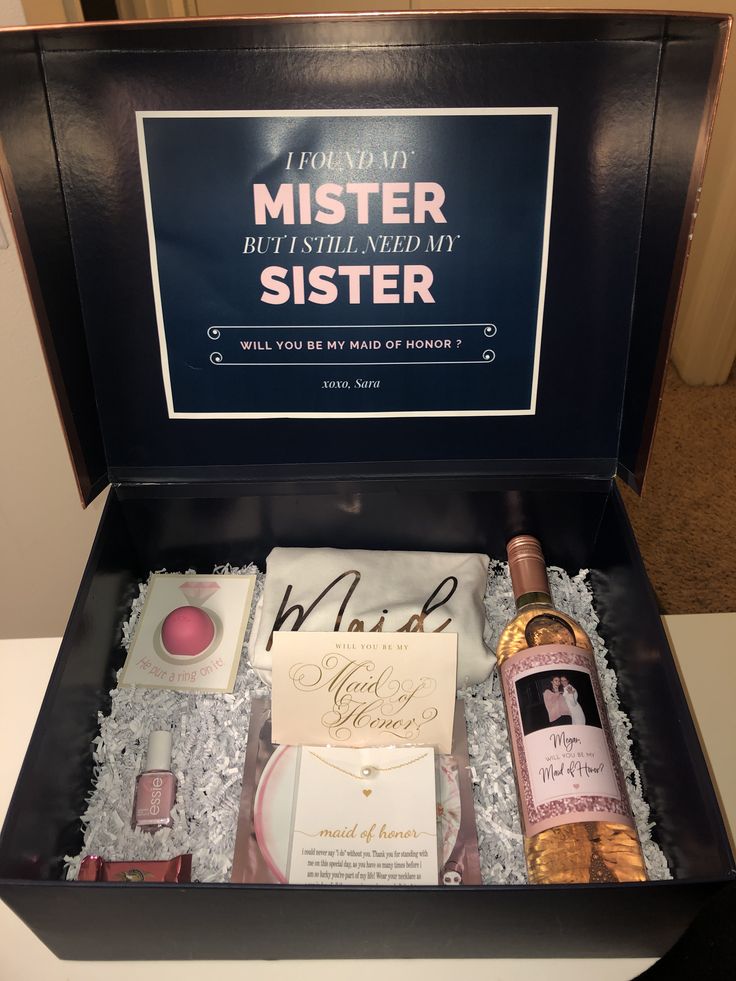 a bottle of wine in a gift box with some other items inside the box and on top of it