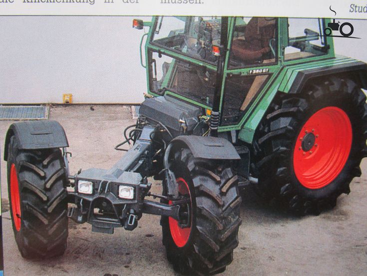 a large tractor parked on top of a parking lot next to a building with an advertisement in front of it