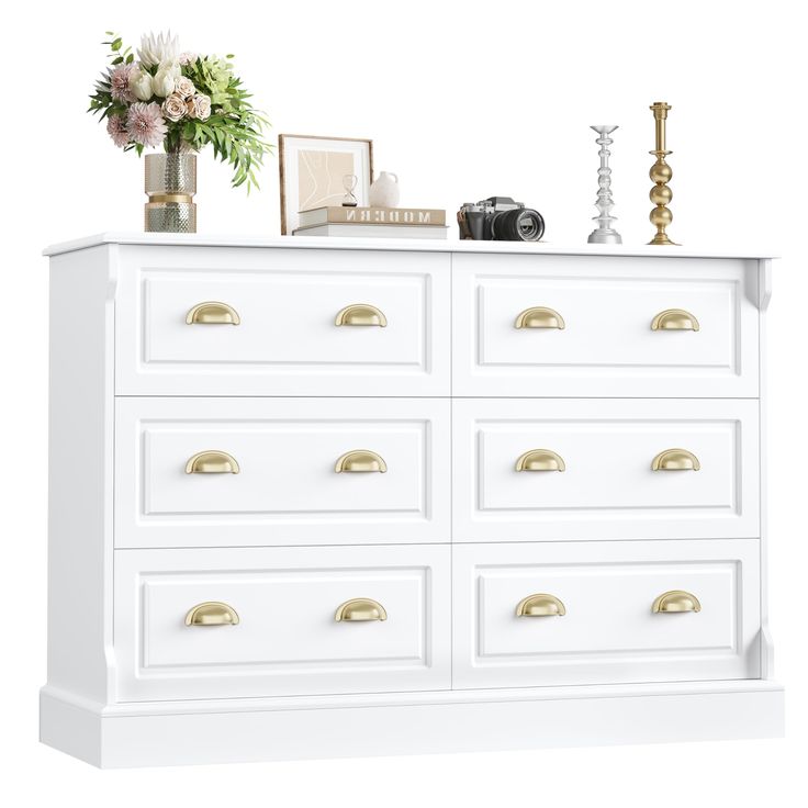 a white dresser with gold handles and drawers