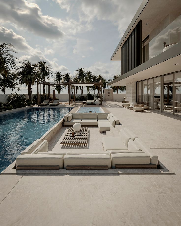 an outdoor lounge area next to a swimming pool