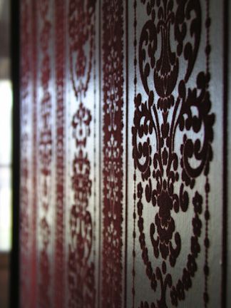 the wall is covered in intricate designs on it's sidewalls, and has been painted with dark red paint