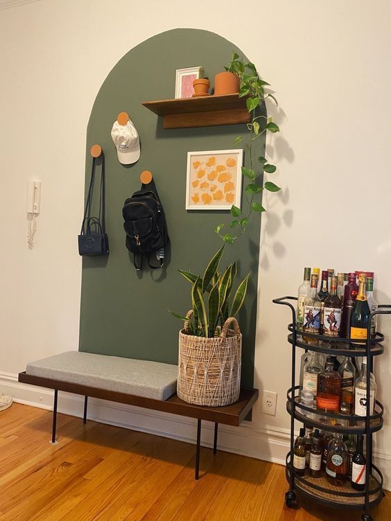 a room with a shelf, plant and purse on the wall next to a bench