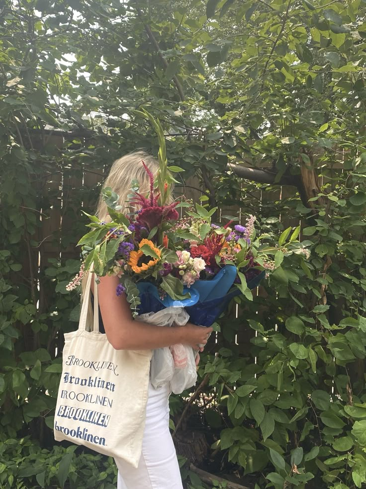 a woman holding a bouquet of flowers in her hands