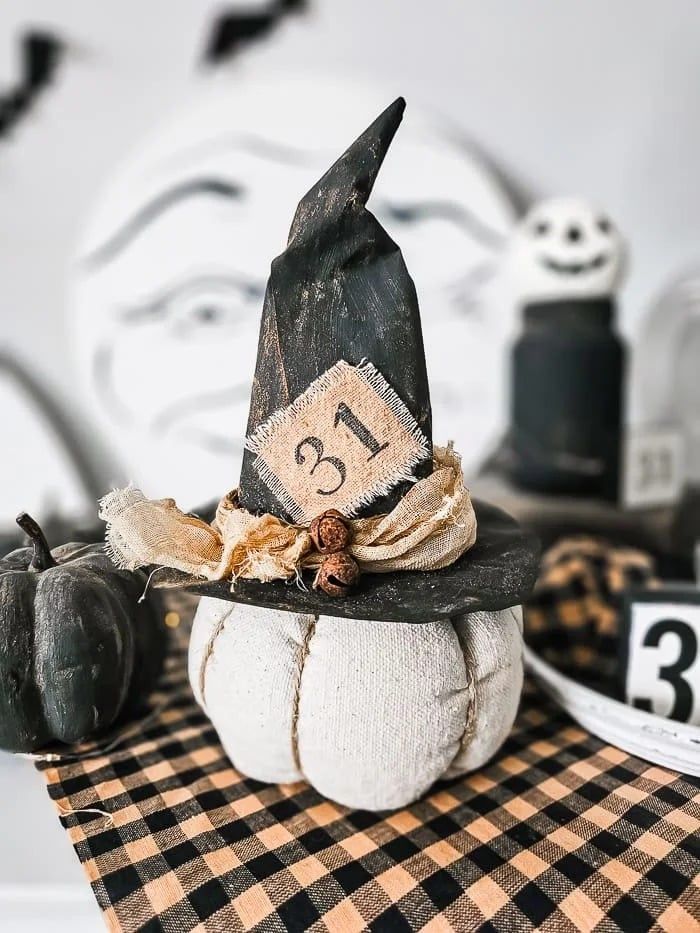 a black and white pumpkin with a witch's hat on top