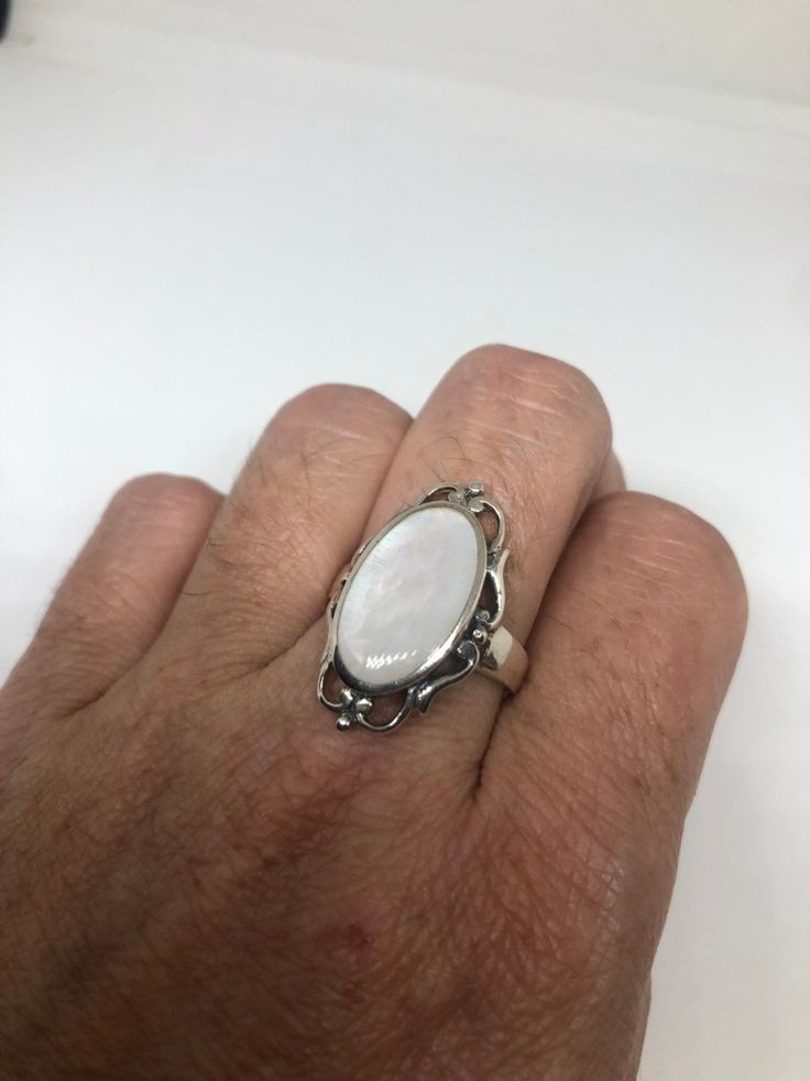 Lovely polished sterling silver has the look of Deco with a huge white Mother Of Pearl set in very detailed vintage filigree Size 7.75 We can size these with an additional $10-$20 fee for the jeweler All rings are shipped in a nice gift box. Check out our over a THOUSAND great reviews Engraving is $4 per letter and is not always perfect depending on the piece. It can take a few days if the jeweler is busy. This is payable to Paypal Judithsltd@gmail.com White Cabochon Jewelry For Formal Occasions, Ornate White Filigree Ring With Intricate Design, White Cabochon Ring For Formal Occasions, White Cabochon Rings For Formal Occasions, Classic White Engraved Rings, Classic Engraved White Rings, Elegant White Engraved Rings, Classic White Filigree Ring With Intricate Design, Vintage White Oval Cabochon Ring