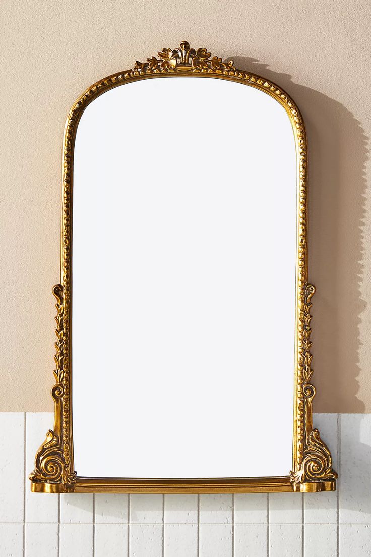 an ornate gold framed mirror on the wall