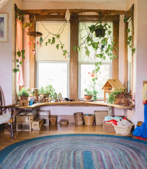 a living room filled with lots of plants next to a window covered in potted plants