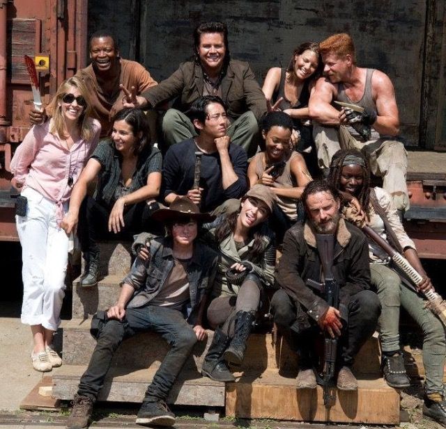 a group of people are posing for a photo on the steps in front of a truck