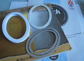 two metal rings sitting on top of a piece of paper next to scissors and tape