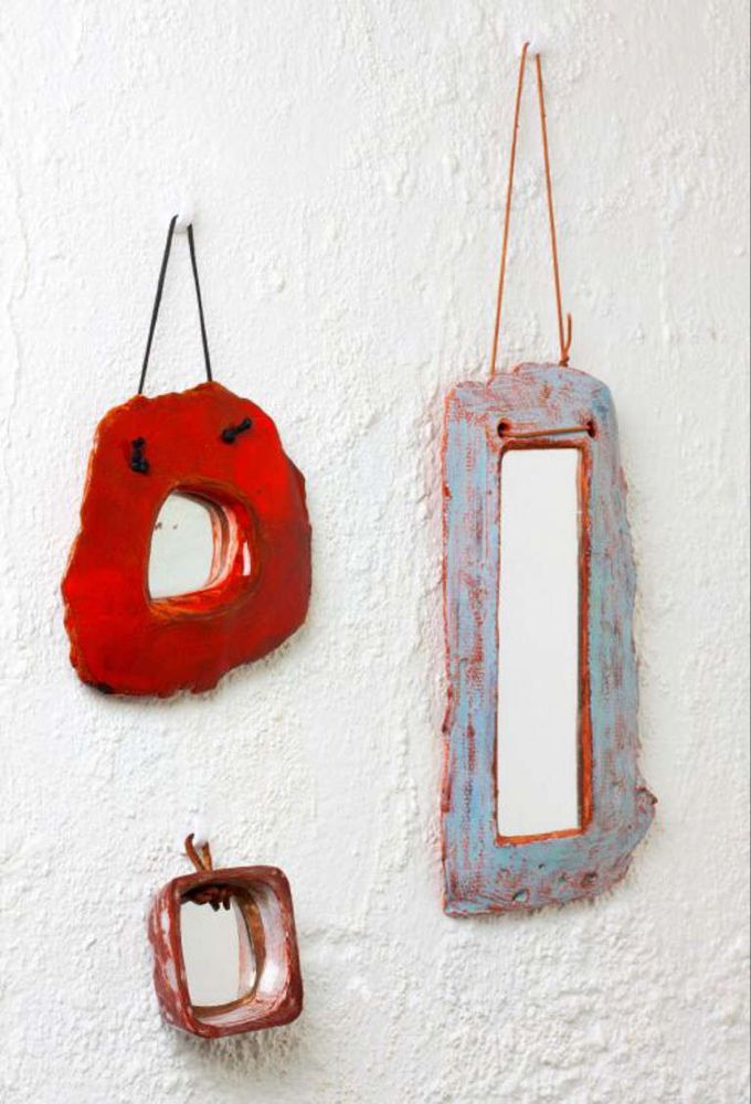 two red and one blue hanging on the side of a white wall next to each other