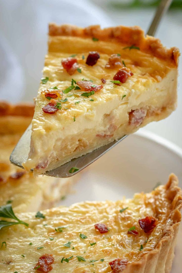 a piece of quiche being lifted from a white plate