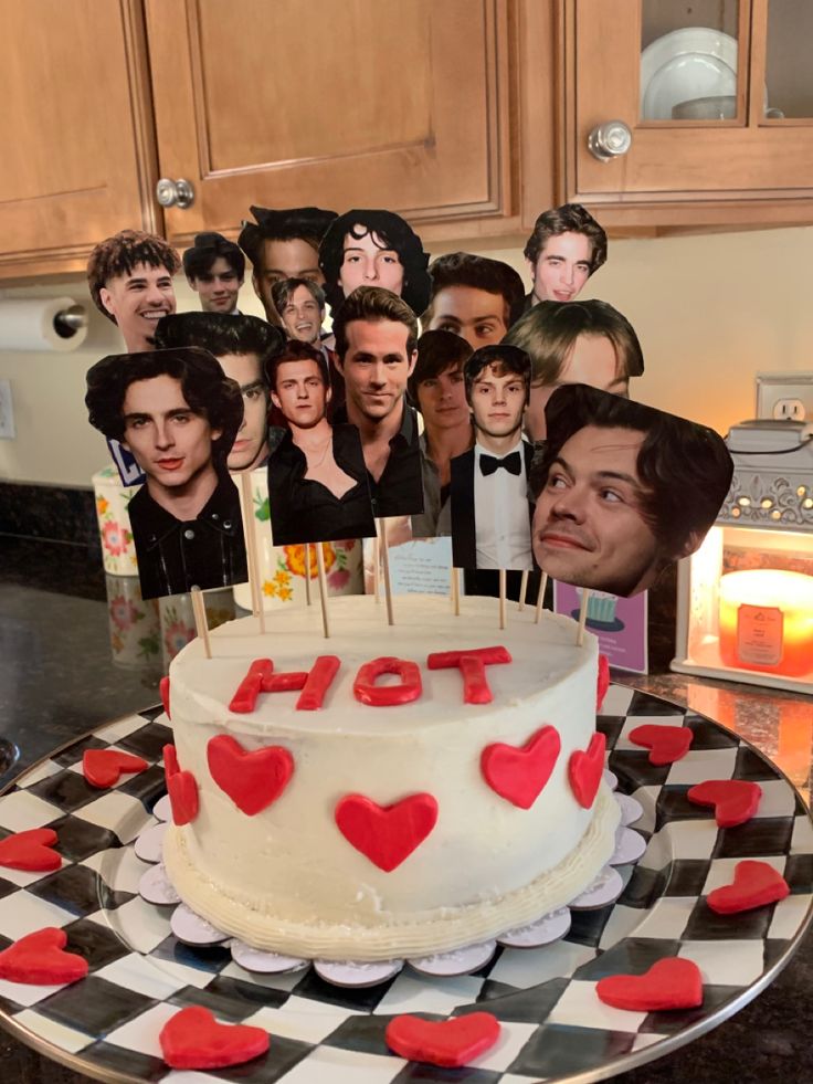 a group of people standing behind a cake with hearts on it and candles in the middle