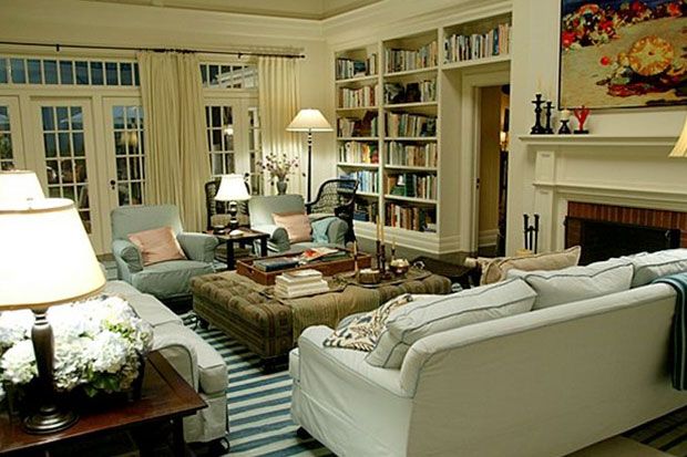 a living room filled with furniture and a fire place in front of a book shelf