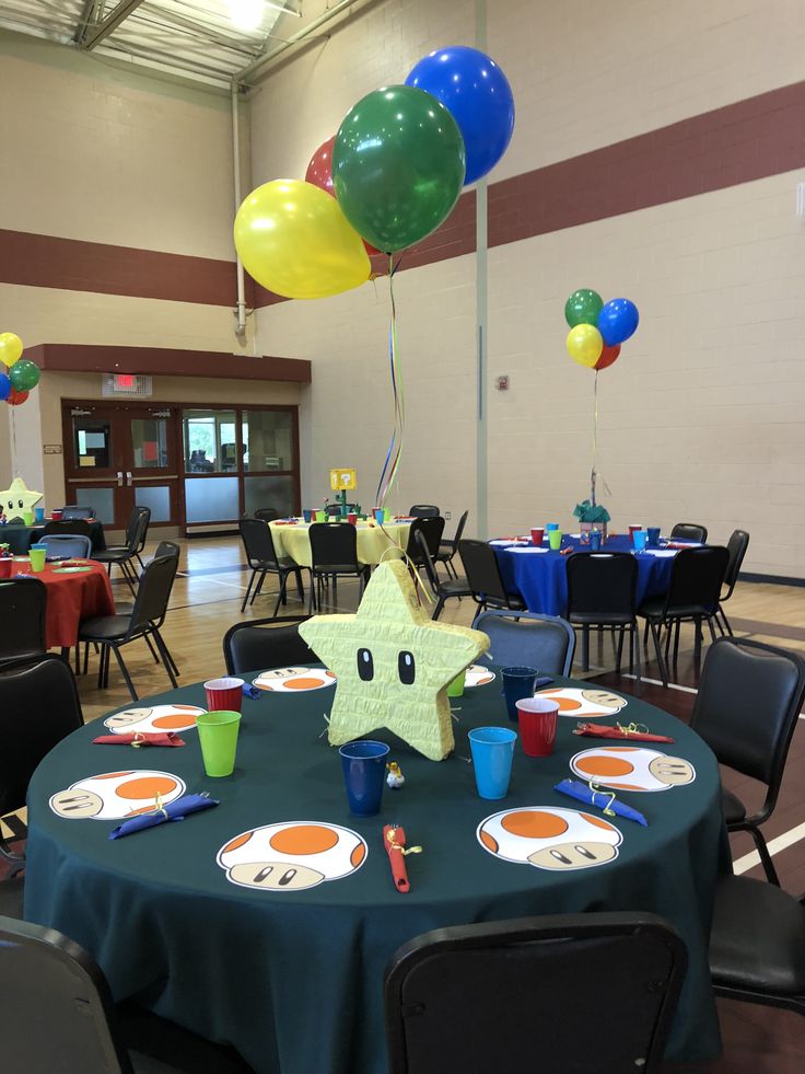 a table set up with balloons, plates and cups