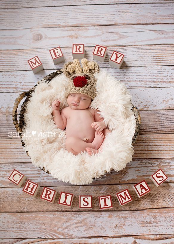 a baby is laying in a basket with the word merry christmas spelled out on it