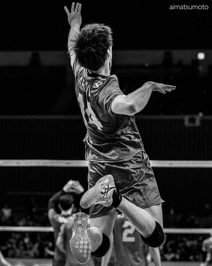 a man jumping up in the air to hit a volleyball