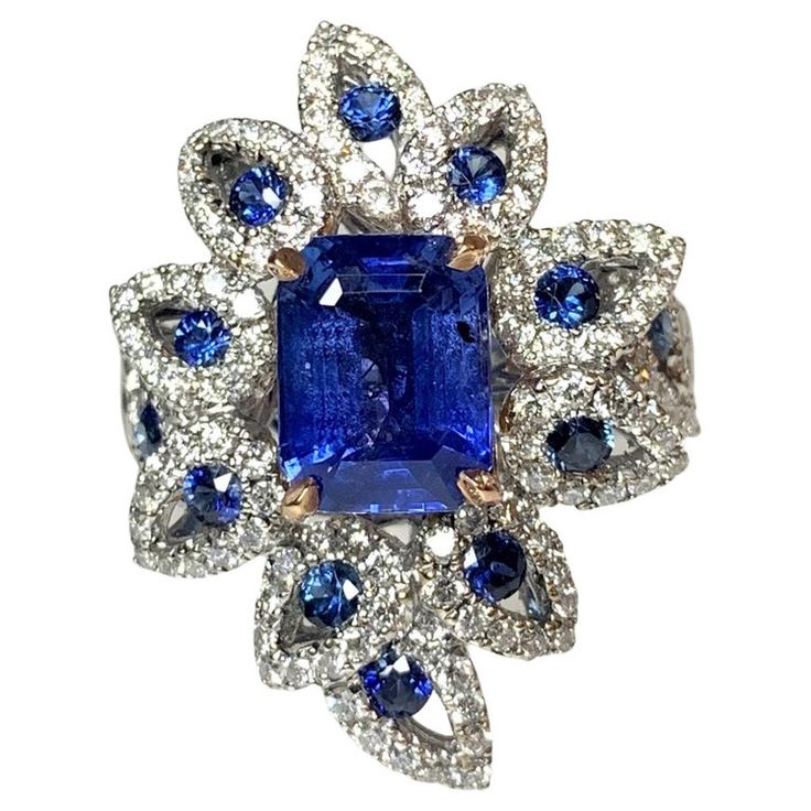 An exceptional piece with meticulous detailing to add to your fine jewelry collection. Here is an 18k white gold one of a kind richly saturated blue sapphire ring featuring a 3.17 carat emerald- cut center stone set in rose gold prongs, surrounded by a unique pear shaped diamond halo with a total diamond weight of 1.10 carats centered with round sapphires weighing 0.58 carats. *Approximate stone measurements: Height: 9 mm Width: 7 mm *Approximate ring weight: 8.84 grams Quotes Sassy, Blue Sapphire Diamond Ring, Saturated Blue, Round Sapphire, Blue Sapphire Diamond, Sapphire Diamond Ring, Pear Shaped Diamond, Blue Sapphire Rings, Fine Jewelry Collection