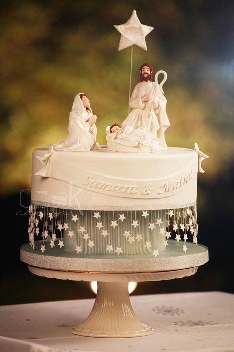 a white cake topped with two figurines sitting on top of it