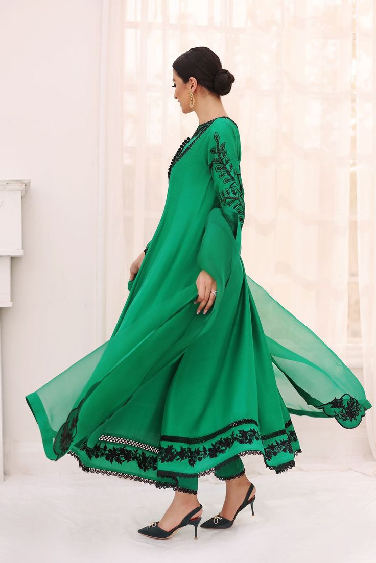 Canvassed on a long pure raw silk emerald green hue with hand embroidered details in a flowy pishwas silhoutte, the sleeves feature a cutwork motif and the hem is adorned with an intricate floral border. Accompanying this gorgeous design is a pure organza embroidered dupatta alongside matching straight lacey trouser. T Bollywood Style Long Sleeve Dress With Embroidered Border, Long Sleeve Anarkali Set With Embroidered Border For Wedding, Semi-stitched Georgette Dress With Embroidered Border, Elegant Green Dresses With Embroidered Border, Green Anarkali Set With Embroidered Border, Green Silk Anarkali Set With Embroidered Border, Green Dresses With Intricate Embroidery And Traditional Drape, Green Traditional Wear With Intricate Embroidery Floor-length, Green Floor-length Traditional Wear With Intricate Embroidery