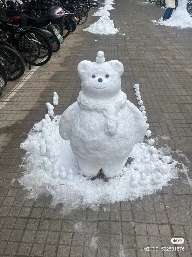 a snowman sitting on the ground next to parked bikes