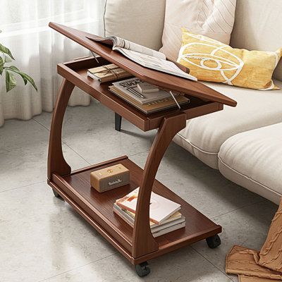 a living room with a white couch and a wooden shelf on the floor next to a coffee table