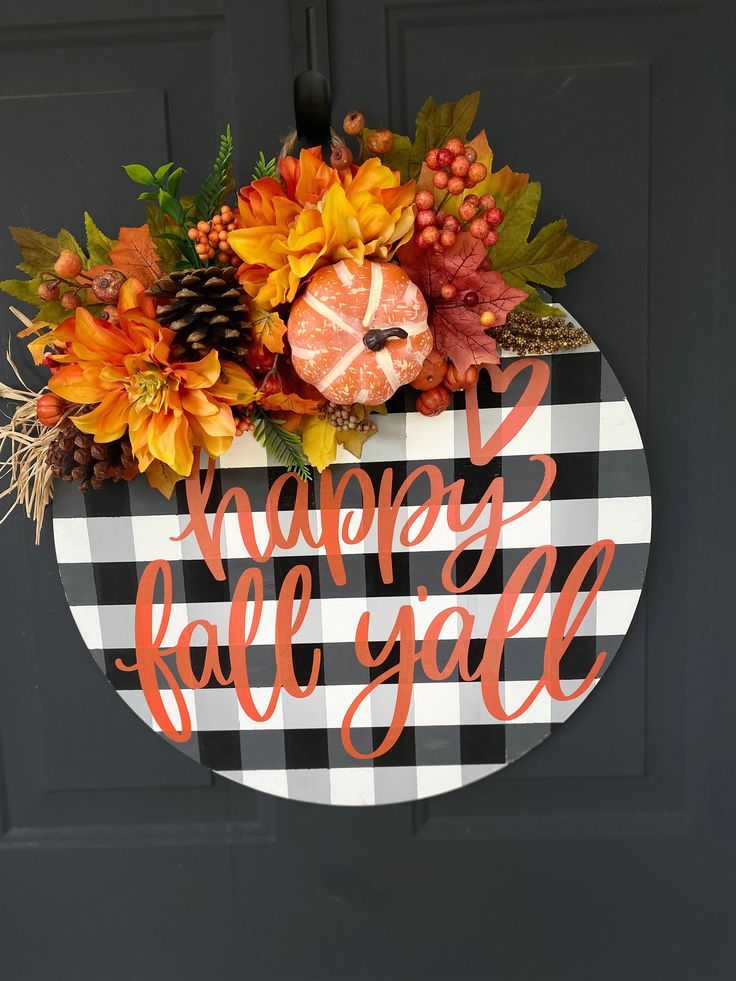 a black and white checkered door hanger that says happy fall with pumpkins, gourds, and leaves