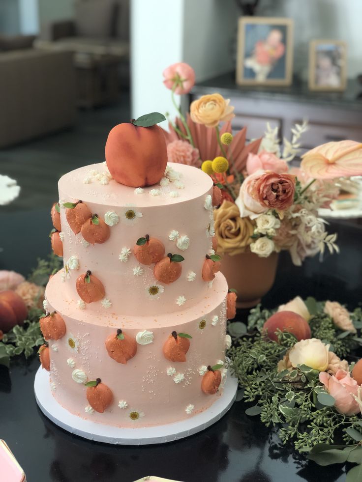 a three tiered cake sitting on top of a table next to flowers and other decorations