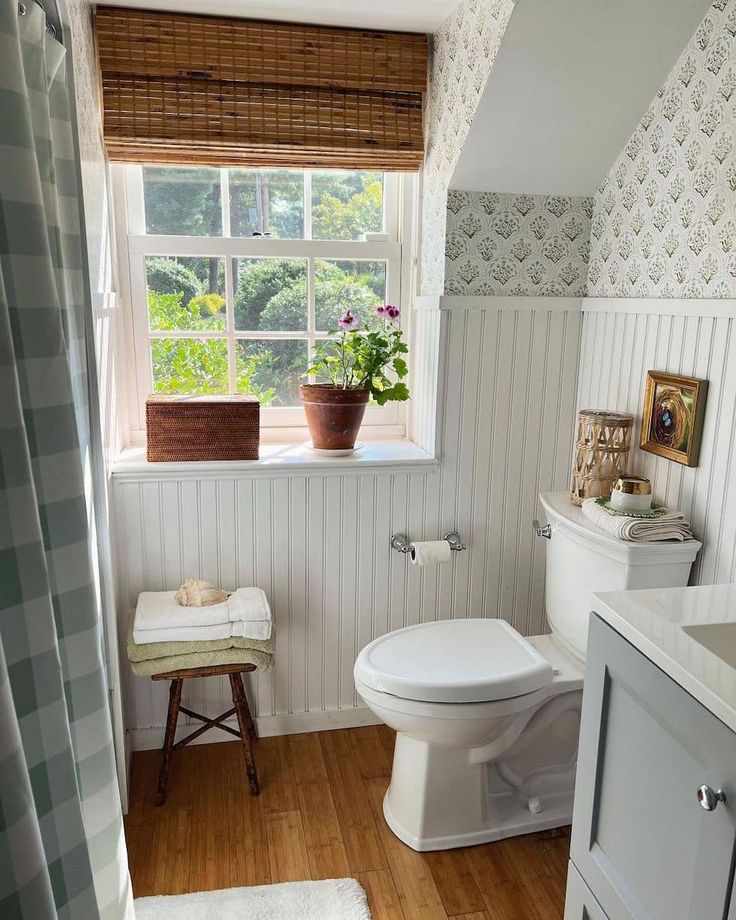 a white toilet sitting next to a window in a bathroom