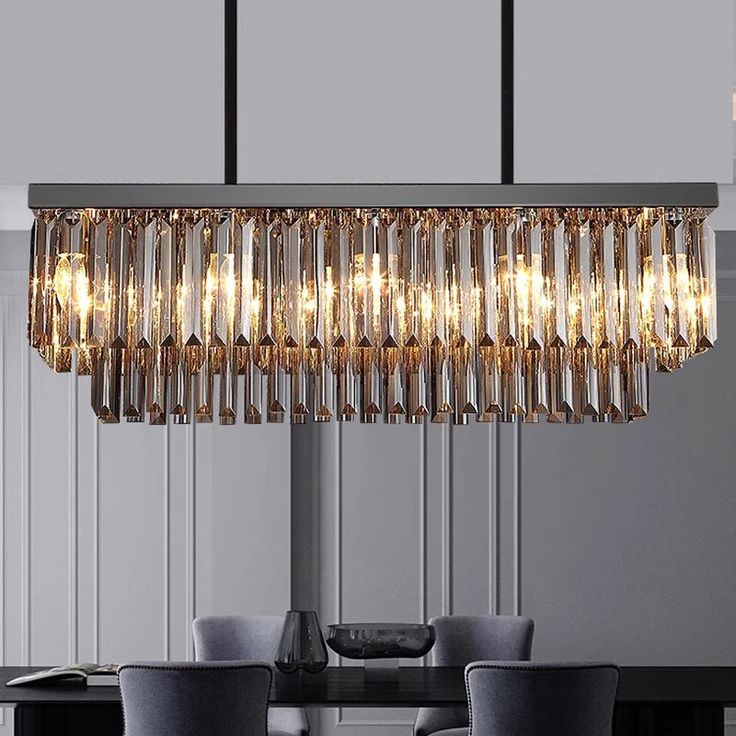 a modern chandelier hanging over a dining room table