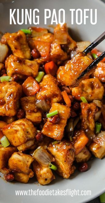 a white bowl filled with chicken and vegetables next to chopsticks on top of it