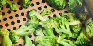 broccoli florets are being cooked in a colander