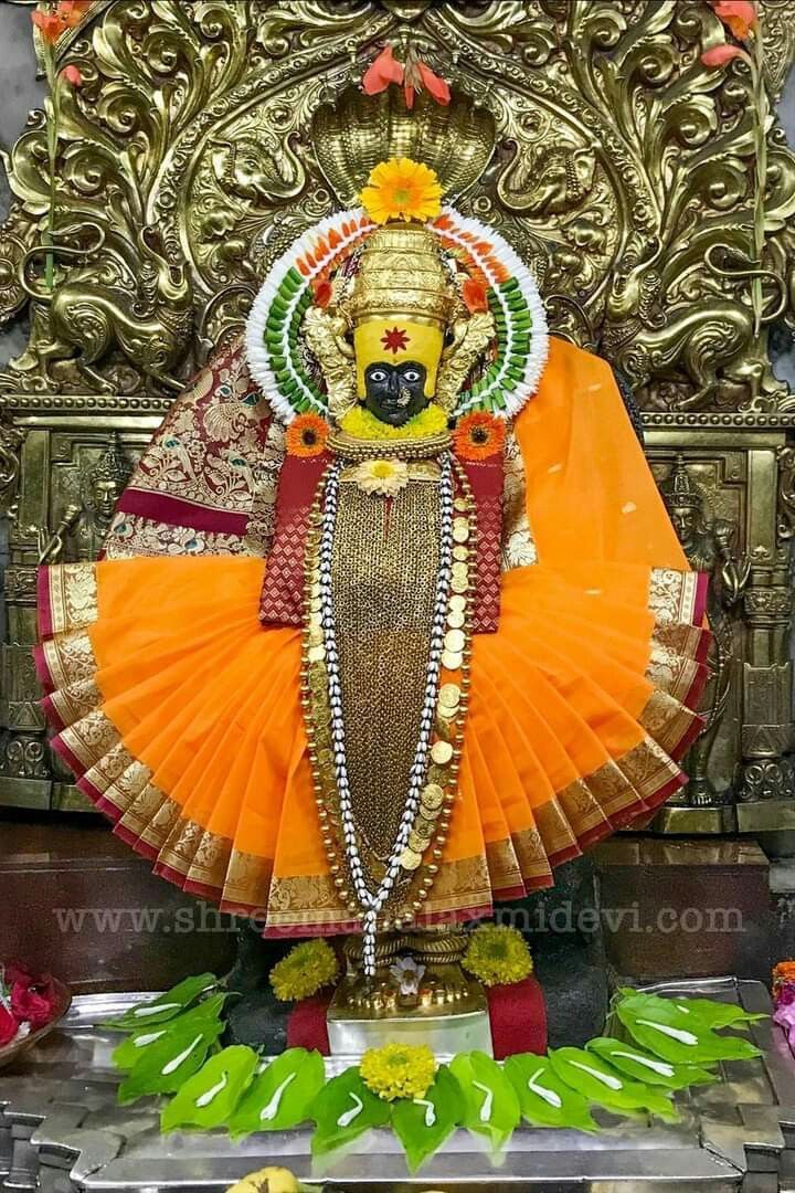 an idol is displayed in front of a gold statue