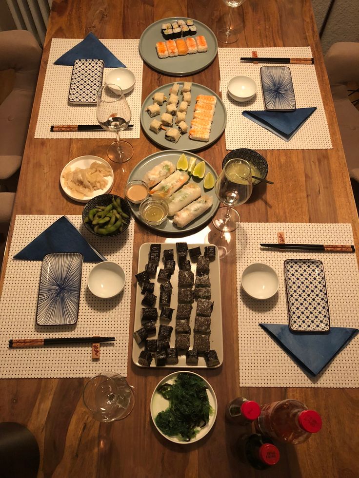 a wooden table topped with plates and bowls filled with different types of food on top of it