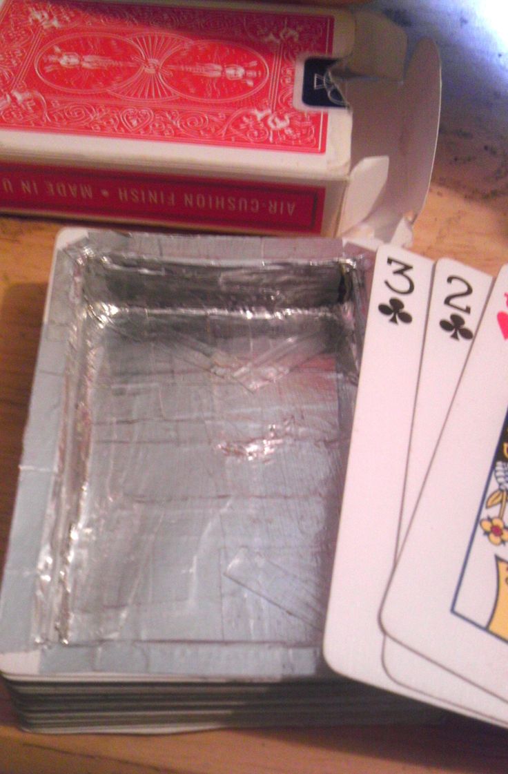 playing cards are sitting on top of each other in front of some boxes and books