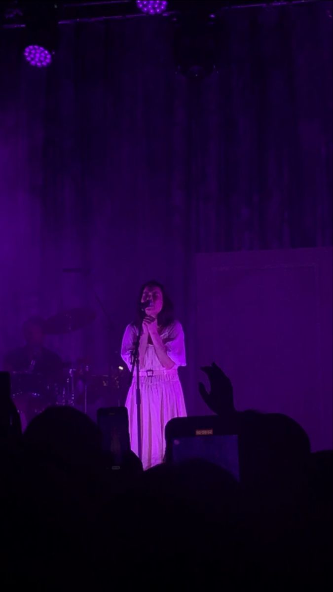 a woman standing on top of a stage holding a microphone