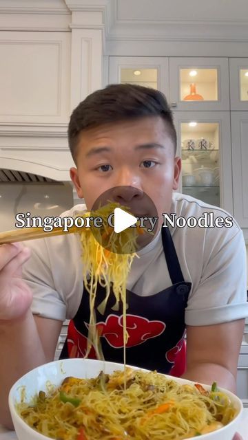 the man is eating noodles with chopsticks in his mouth