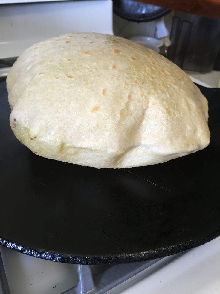 a black plate topped with a doughnut on top of a stove