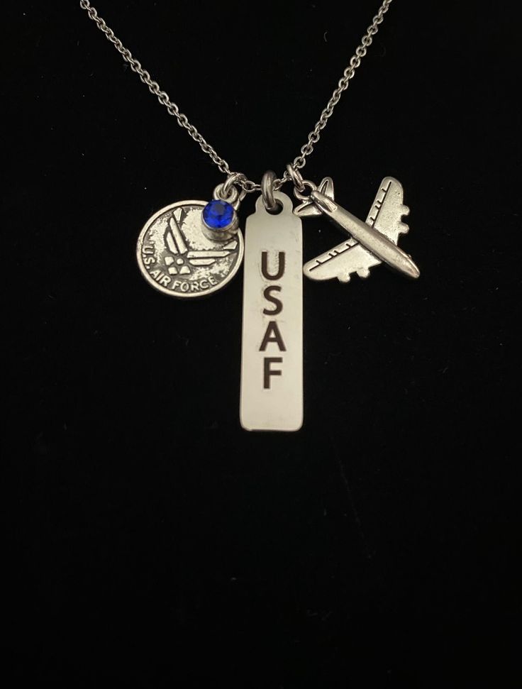 "For an Airman, wife or mom.  They would be proud to wear this necklace. It is the perfect gift for anyone who knows the commitment wrapped up in those four letters. This silver tone necklace has charms depicting the Air Force wings emblem with a blue gem, a laser engraved \"USAF\" (United States Air Force) stainless steel charm and an airplane. * 18\" Stainless Steel chain * Lobster claw closure * Perfect for completion of BCT,  or for the loved one of an airman. * This piece comes packaged in a gift box suitable for presentation" Personalized Adjustable Blue Charm Necklaces, Personalized Blue Sterling Silver Jewelry, Nickel-free Blue Metal Charm Necklaces, Blue Sterling Silver Jewelry For Personalized Gift, Personalized Blue Engraved Jewelry, Personalized Engraved Blue Jewelry, Personalized Engraved Blue Jewelry Gift, Silver Hand Stamped Metal Necklace, Personalized Blue Sterling Silver Necklace