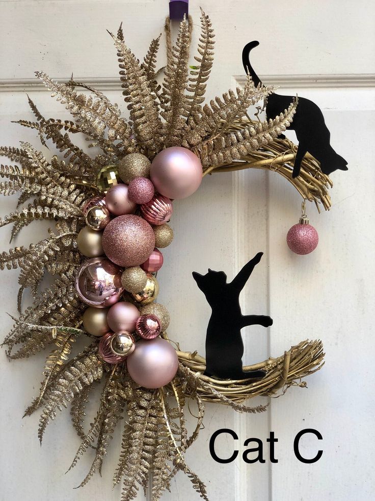 a wreath with ornaments and a cat on it