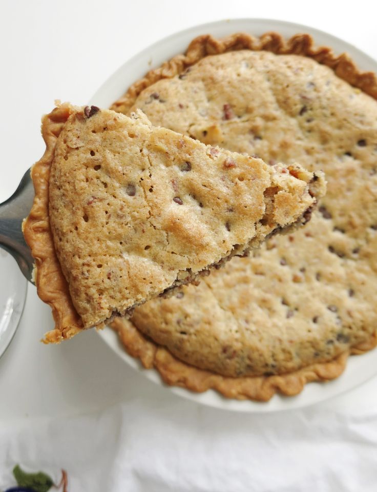 a pie on a white plate with a fork in it and another pie behind it